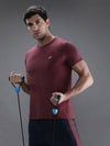Man wearing a maroon melange solid t shirt on a light gray background