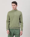 Man wearing a green green solid cotton sweatshirt on a light gray background