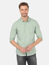 Man wearing a green green solid full sleeve casual shirt on a light gray background