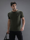 Man wearing a green solid sport fit green t shirt with casual styling on a gray background