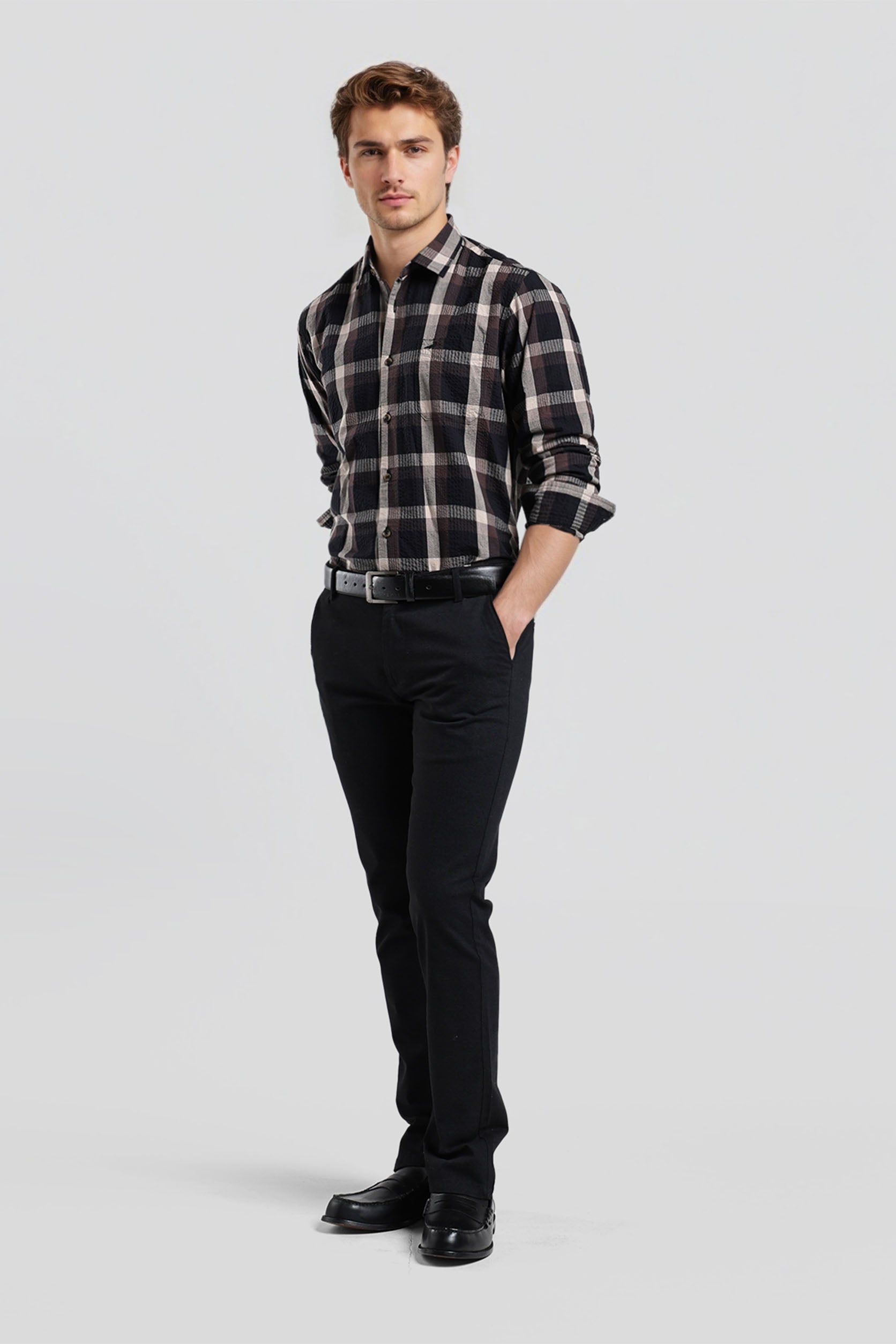 Man wearing a plaid shirt and black pants on a white background