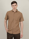Man wearing a brown brown solid half sleeve linen shirt with casual styling on a gray background