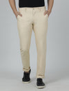 Man wearing a beige solid slim fit casual trouser beige with casual styling on a gray background