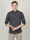 Man wearing a navy casual dark navy printed full sleeve 100% cotton shirt on a light gray background