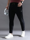 Man wearing a black solid black comfort fit joggers on a light gray background