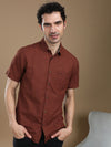 Man wearing a brown brown printed half sleeve 100% cotton shirt on a light gray background