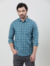 Man wearing a blue casual blue checked full sleeve shirt on a light gray background