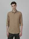 Man wearing a brown khaki brown checked full sleeve 100% cotton casual shirt on a light gray background