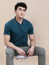 Man wearing a blue teal blue solid polo t shirt with pocket with casual styling on a gray background