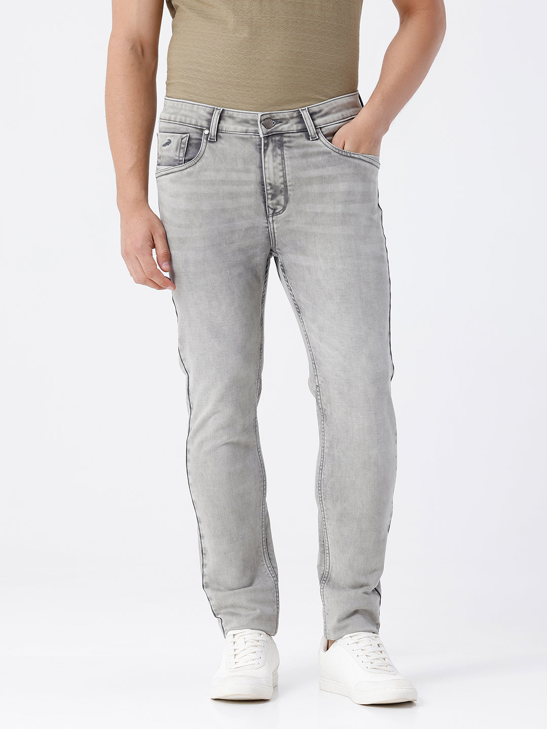 Man wearing a grey light grey knit slim fit jeans on a light gray background