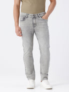 Man wearing a grey light grey knit slim fit jeans on a light gray background