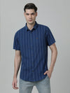 Man wearing a navy indigo navy striped half sleeve 100% cotton shirt on a light gray background