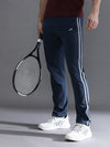 Man wearing a navy solid slim fit navy melange track pant on a light gray background