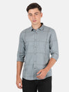Man wearing a grey dark grey checked full sleeve shirt on a light gray background