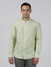 Man wearing a green light green solid full sleeve linen shirt with casual styling on a gray background