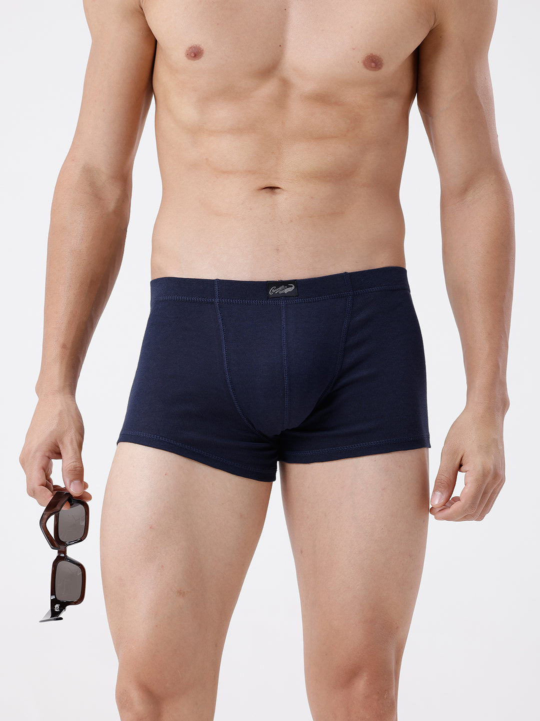 Man wearing navy blue boxer briefs on a white background