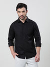 Man wearing a black black solid casual full sleeve 100% cotton shirt with casual styling on a gray background
