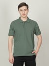 Man wearing a green light green solid polo t shirt on a light gray background