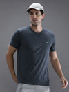 Man wearing a denim melange solid t shirt with casual styling on a gray background