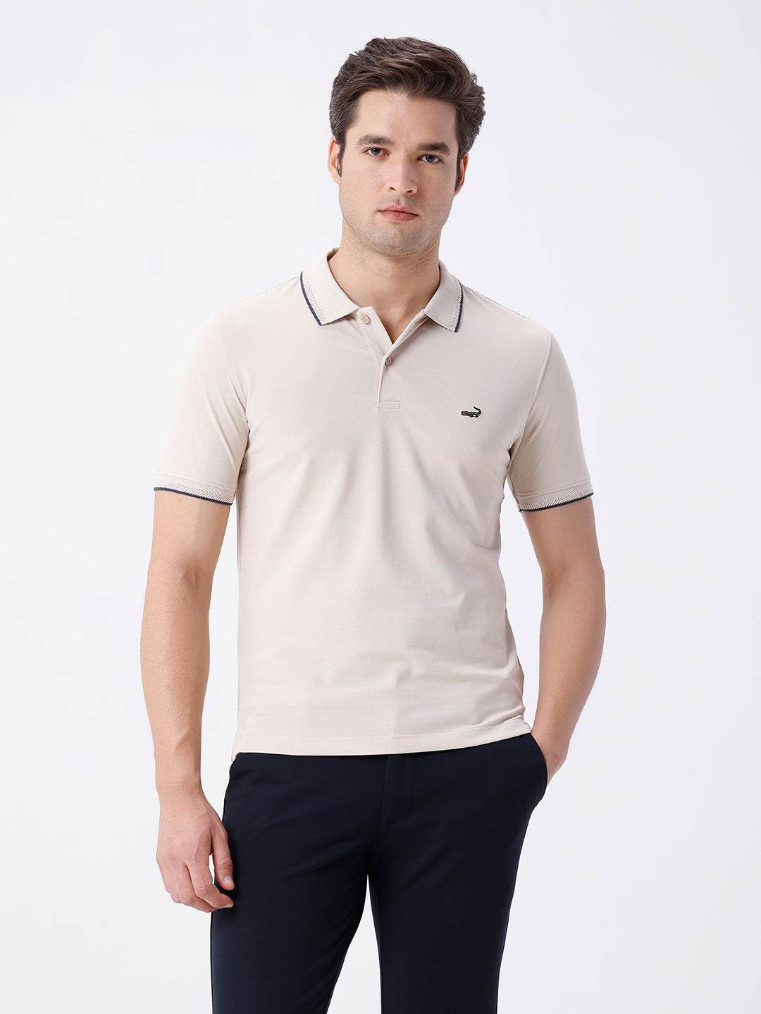Man wearing a beige breeze stretch polo t shirt beige on a light gray background