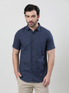 Man wearing a navy navy printed half sleeve casual 100% cotton shirt on a light gray background