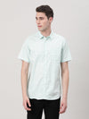 Man wearing a green casual green checked half sleeve 100% cotton shirt with casual styling on a gray background
