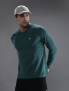 Man wearing a green green melange solid t shirt on a light gray background