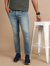 Man wearing a blue light blue solid mid rise slim fit jean with casual styling on a gray background