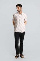 Man wearing a white floral shirt and black pants on a light gray background