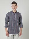 Man wearing a blue blue striped full sleeve casual shirt on a light gray background