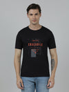 Man wearing a black typography printed single jersey cotton black t shirt with casual styling on a gray background