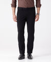 Man wearing a black 4-way stretch techno chino in black on a light gray background