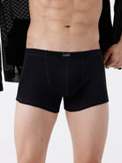 Person wearing black boxer briefs on a white background