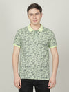 Man wearing a green butterfly green printed polo t shirt with casual styling on a gray background
