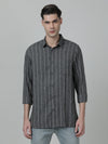 Man wearing a grey dark grey striped full sleeve shirt on a light gray background