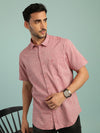 Man wearing a red red striped half sleeve linen shirt on a light gray background