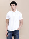 Man wearing a white white solid polo t shirt with pocket with casual styling on a gray background