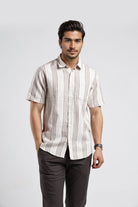 Man wearing a striped shirt and dark pants on a white background