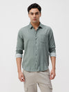 Man wearing a green green striped cotton shirt on a light gray background