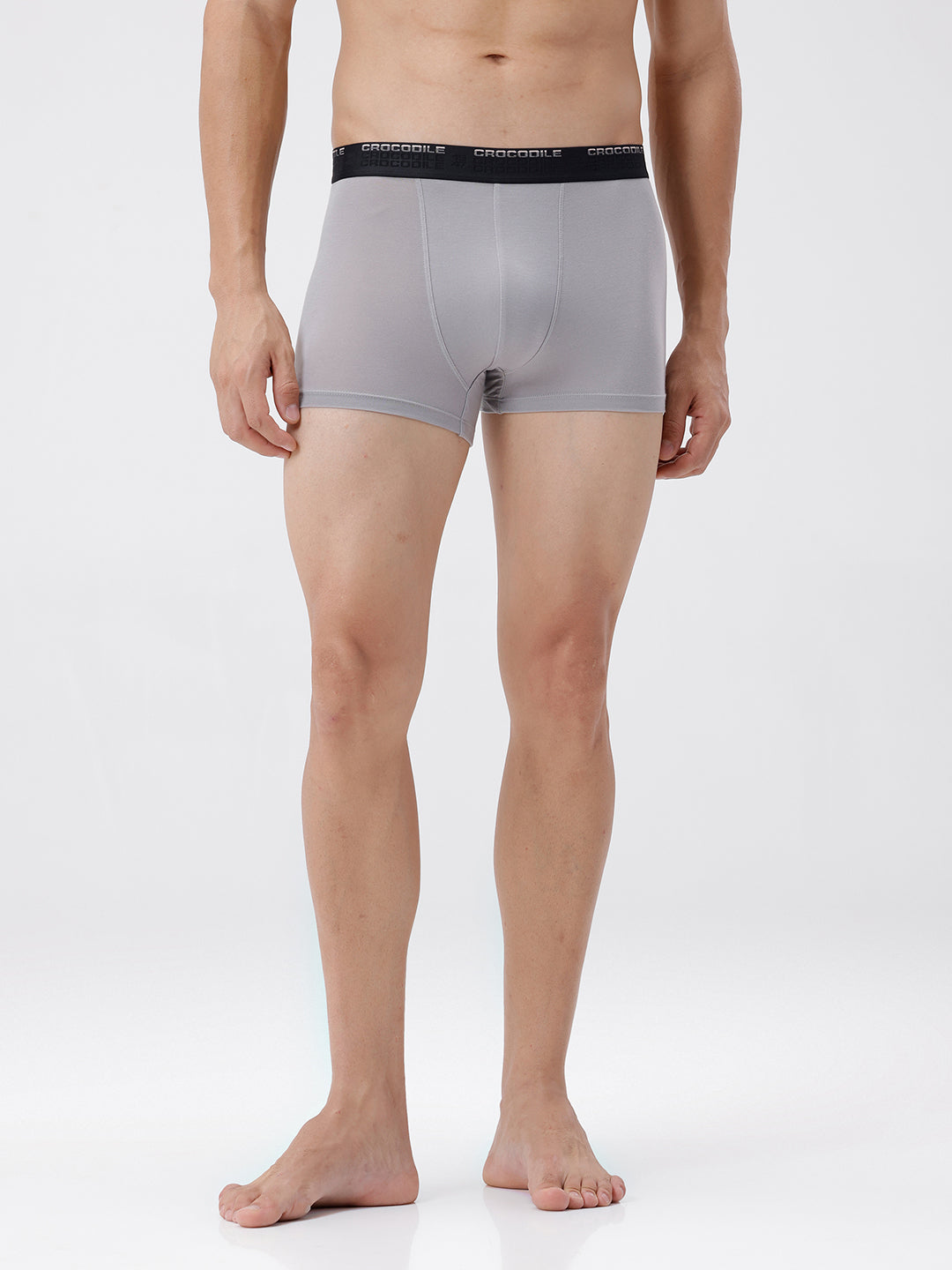 Man wearing gray boxer briefs with a visible brand logo on a white background