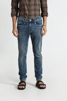 Person wearing blue jeans and a plaid shirt on a white background