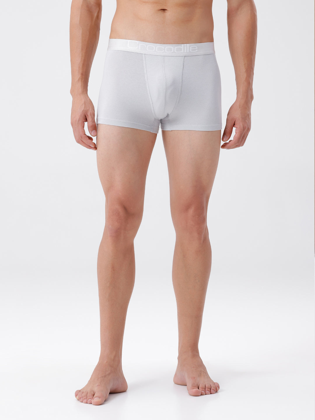 Man wearing white boxer briefs on a plain background