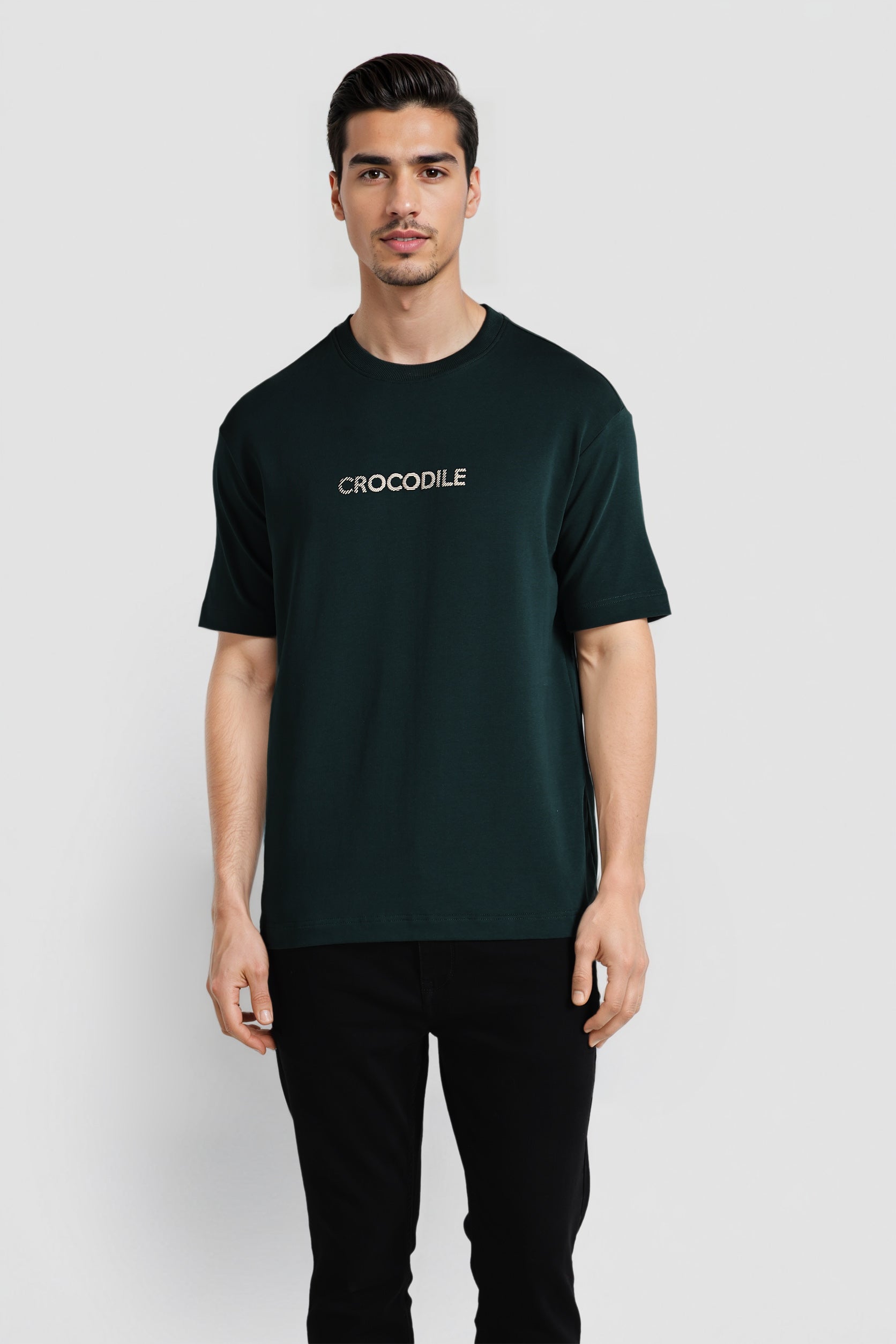 Man wearing a dark green t-shirt with 'CROCODILE' logo on a white background