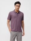 Man wearing a tencel honeycomb pique polo t shirt with casual styling on a gray background