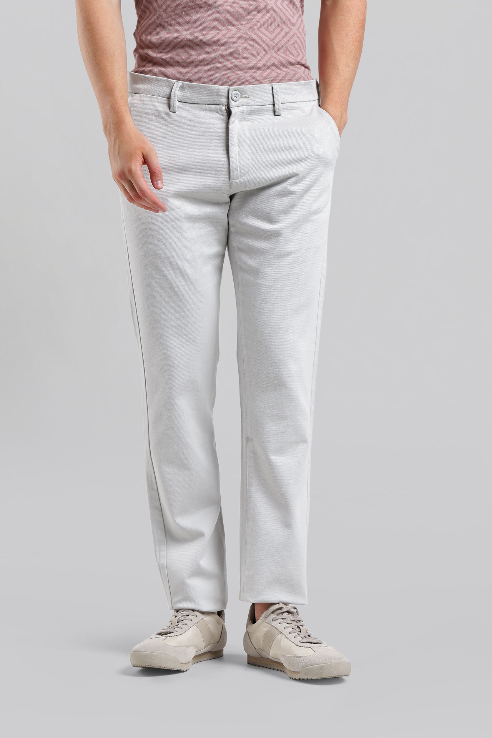 Person wearing light gray jeans on a plain background