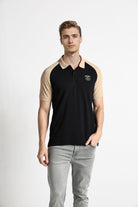 Man wearing a black and beige polo shirt with a logo on a white background