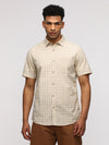 Man wearing a beige comfort fit classic beige shirt for timeless elegance on a light gray background