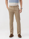 Man wearing a beige beige solid slim fit trousers on a light gray background