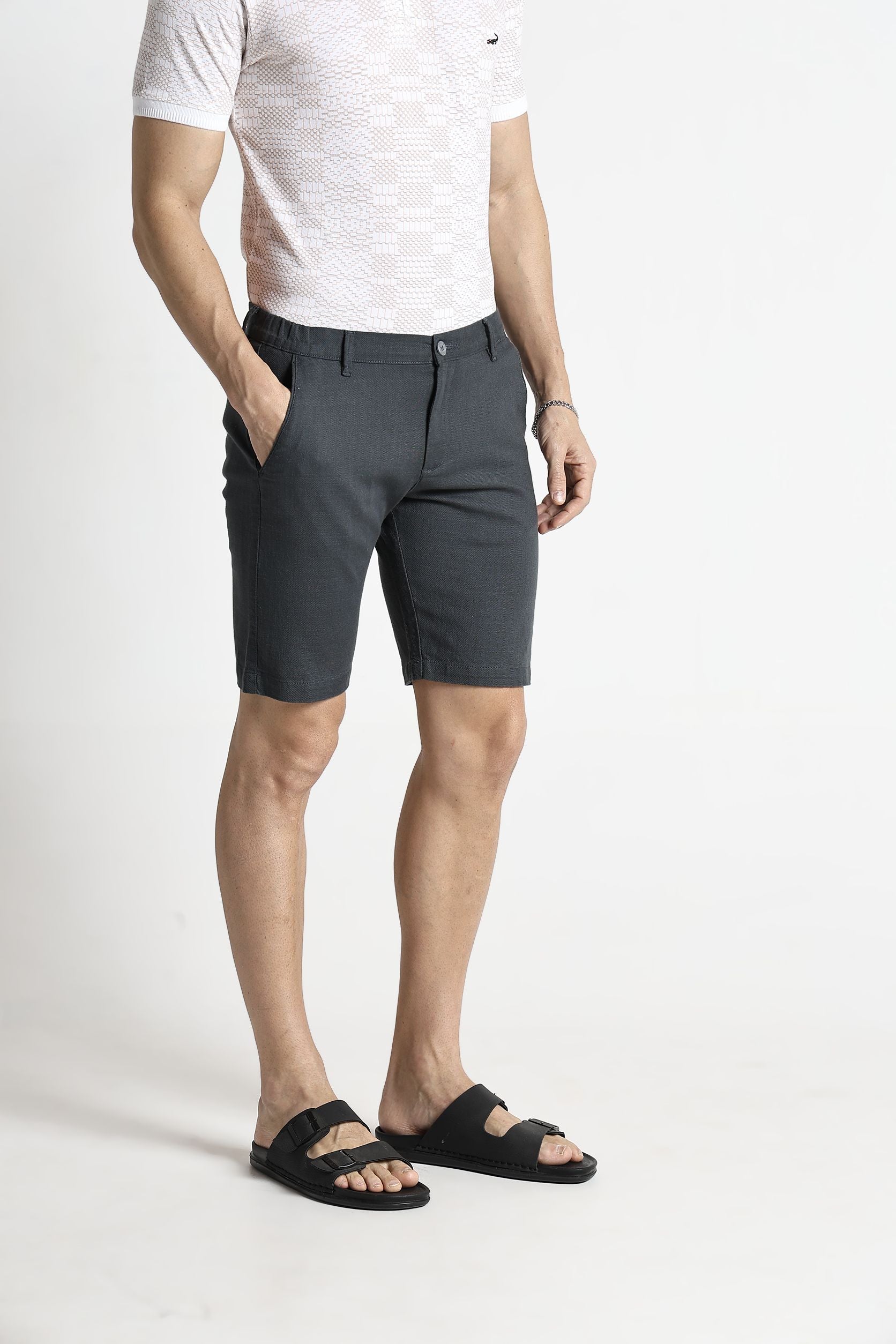 Person wearing gray shorts and a white shirt on a white background