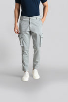 Person wearing gray cargo pants on a plain background